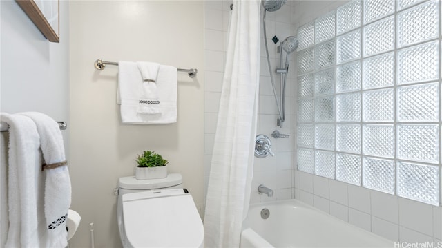 bathroom featuring toilet, a wealth of natural light, and shower / tub combo with curtain