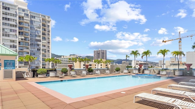 view of pool with a patio and a hot tub