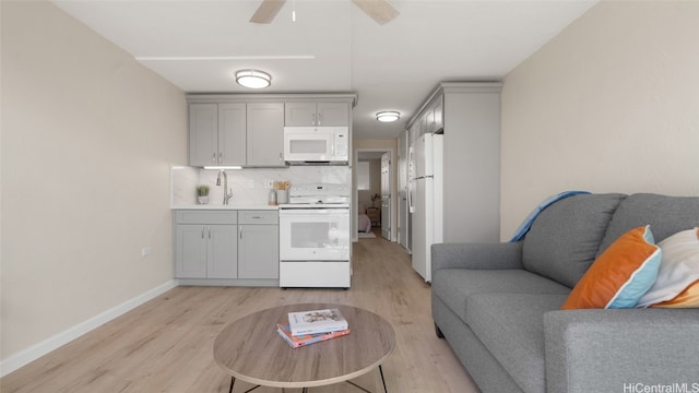 kitchen featuring light hardwood / wood-style floors, tasteful backsplash, gray cabinets, and white appliances