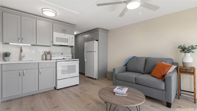 kitchen with white appliances, tasteful backsplash, ceiling fan, gray cabinets, and light hardwood / wood-style flooring