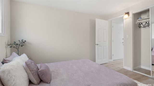 bedroom with light hardwood / wood-style flooring and a closet