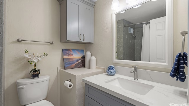 bathroom with vanity, toilet, and walk in shower