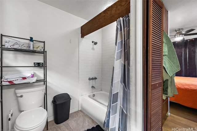 bathroom with shower / bath combination with curtain, toilet, hardwood / wood-style flooring, and ceiling fan