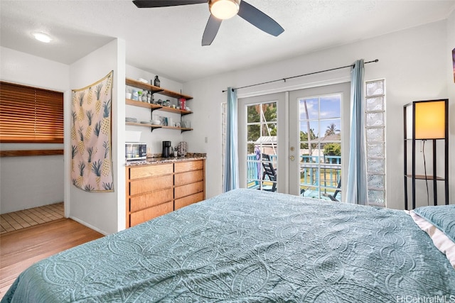 bedroom with french doors, access to exterior, wood-type flooring, a textured ceiling, and ceiling fan