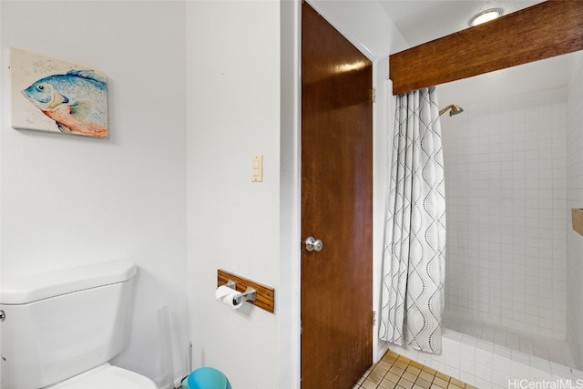 bathroom featuring toilet, a shower with shower curtain, and tile patterned flooring