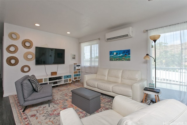 living room with a wall mounted air conditioner and hardwood / wood-style flooring