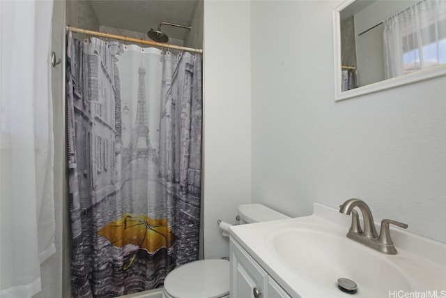 bathroom featuring toilet, vanity, and a shower with shower curtain