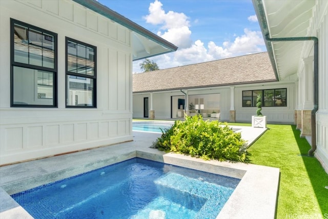 view of pool with a hot tub, a patio, and a yard