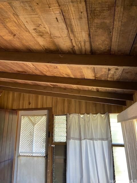 interior details with wood ceiling, beamed ceiling, and wooden walls