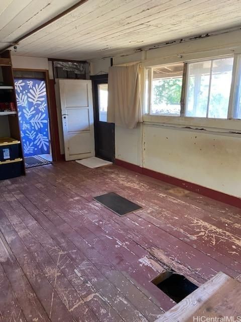 empty room with hardwood / wood-style flooring and wooden ceiling