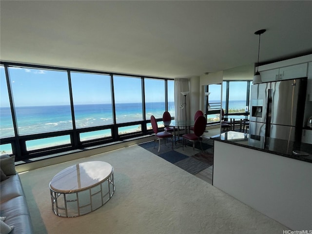 living area featuring a water view and dark colored carpet