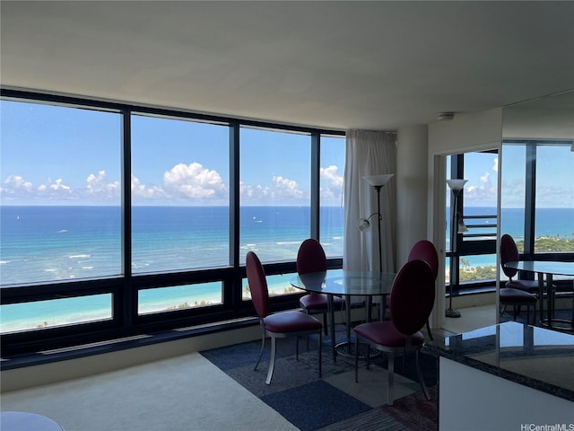 dining space with a water view and carpet flooring