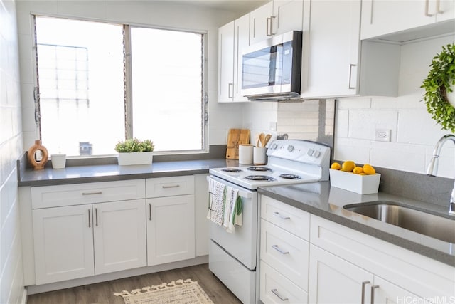 kitchen with decorative backsplash, white cabinetry, dark wood-type flooring, electric stove, and sink