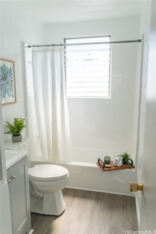 full bathroom featuring vanity, toilet, shower / bathtub combination with curtain, and hardwood / wood-style floors