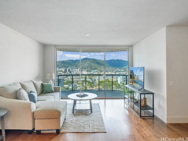 living room featuring a textured ceiling, hardwood / wood-style flooring, and floor to ceiling windows