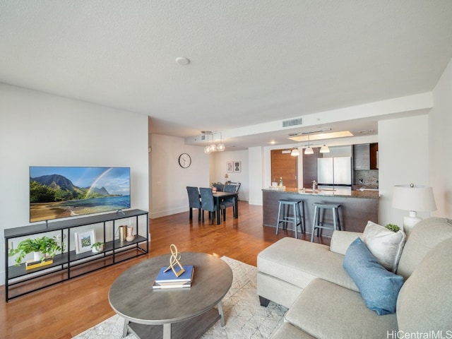 living room featuring light hardwood / wood-style floors and a notable chandelier