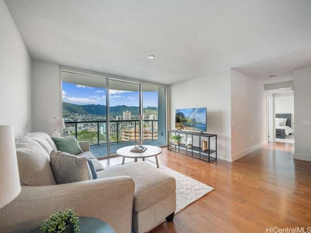 living room with hardwood / wood-style floors, a textured ceiling, and floor to ceiling windows