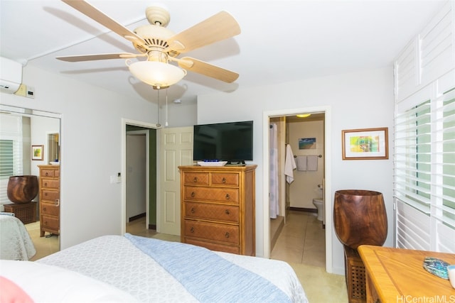 bedroom featuring light carpet, ceiling fan, connected bathroom, an AC wall unit, and a closet