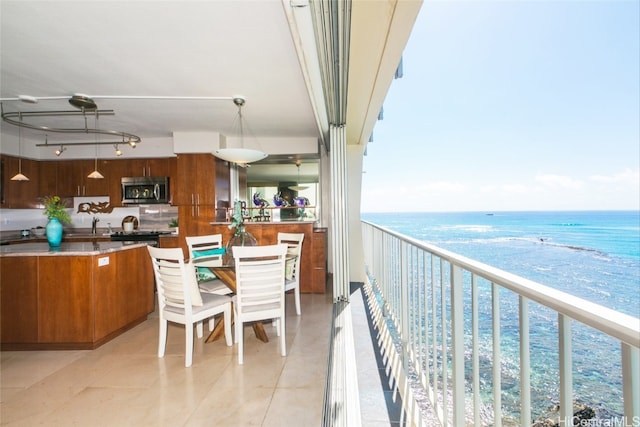 balcony featuring sink, a water view, and a view of the beach