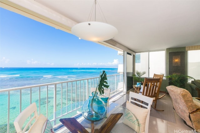 balcony with a water view and a view of the beach