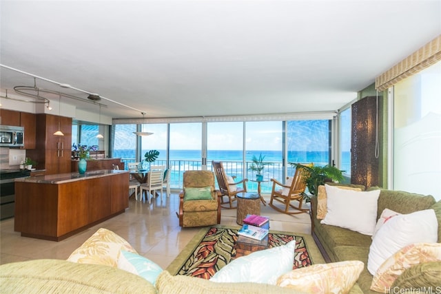 living room with floor to ceiling windows, a water view, and a wealth of natural light