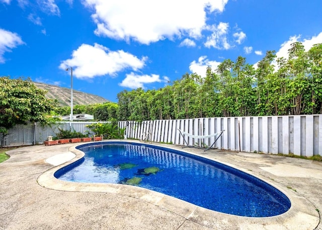 view of swimming pool featuring a mountain view and a patio area