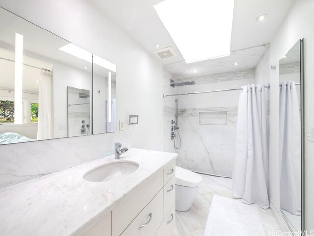 bathroom featuring vanity, a shower with curtain, toilet, and a skylight