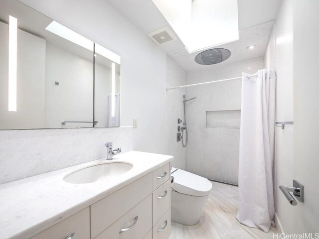 bathroom with vanity, toilet, and walk in shower