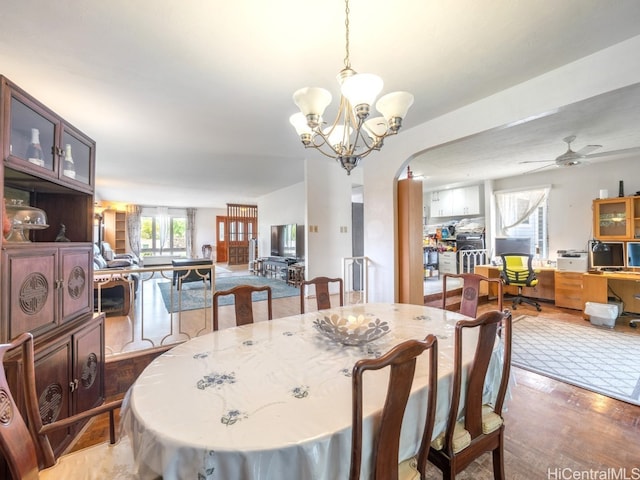 dining space featuring hardwood / wood-style flooring and ceiling fan with notable chandelier