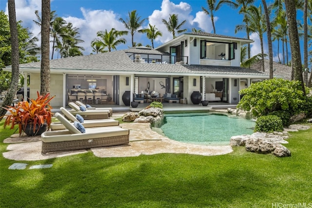 back of property featuring a yard, a patio, and a balcony