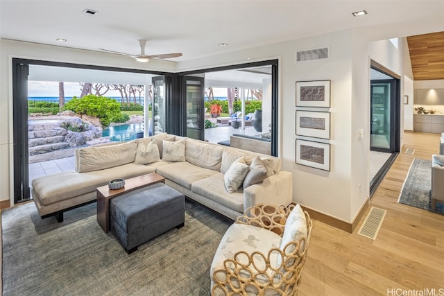 living room featuring light wood-type flooring and ceiling fan