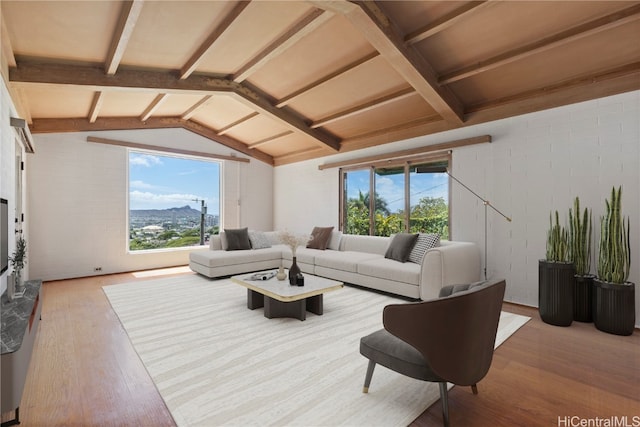 living room featuring wood-type flooring, a mountain view, and vaulted ceiling with beams