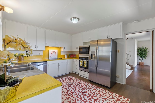 2326 Sonoma St, Honolulu, HI 96822 - kitchen featuring stainless steel appliances, light countertops, dark wood finished floors, white cabinets, and a sink
