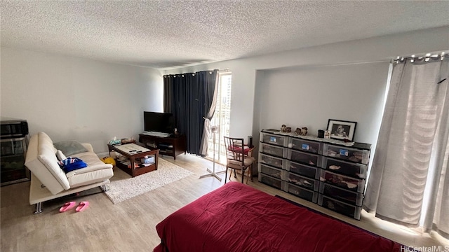 bedroom with a textured ceiling and hardwood / wood-style floors