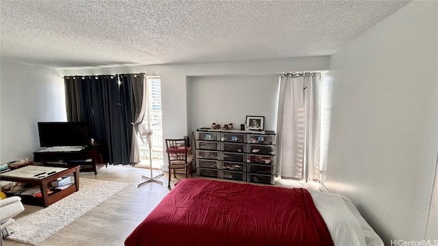 bedroom with light hardwood / wood-style flooring and a textured ceiling