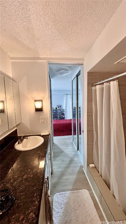 bathroom with vanity, a textured ceiling, and curtained shower