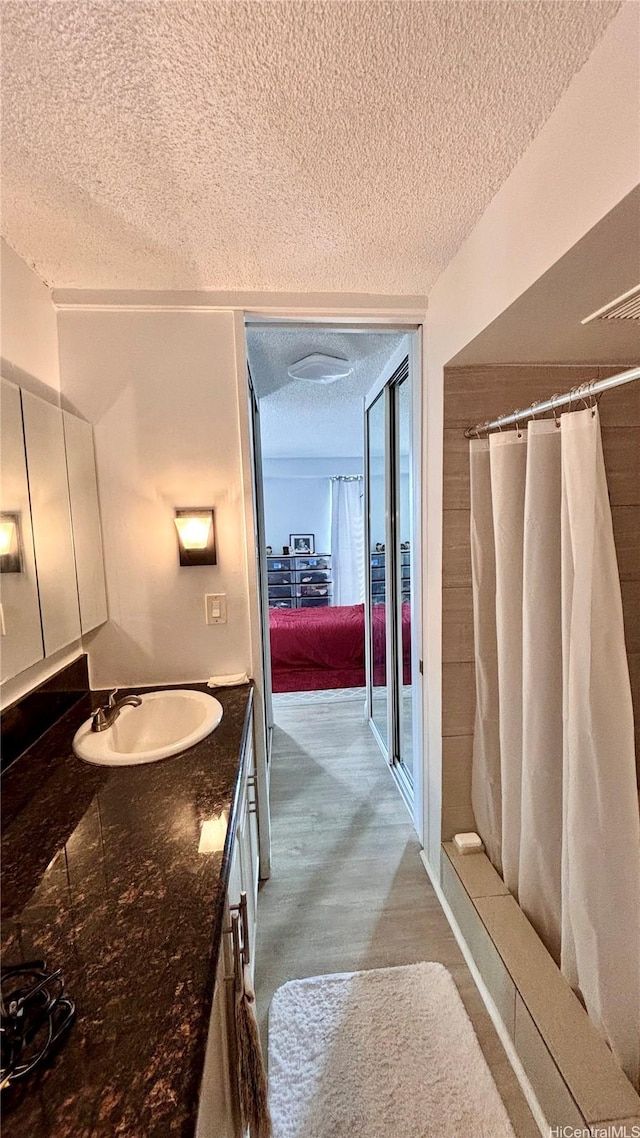 1655 Makaloa St Unit 1009, Honolulu, HI 96814 - bathroom featuring a textured ceiling, a shower with shower curtain, and vanity