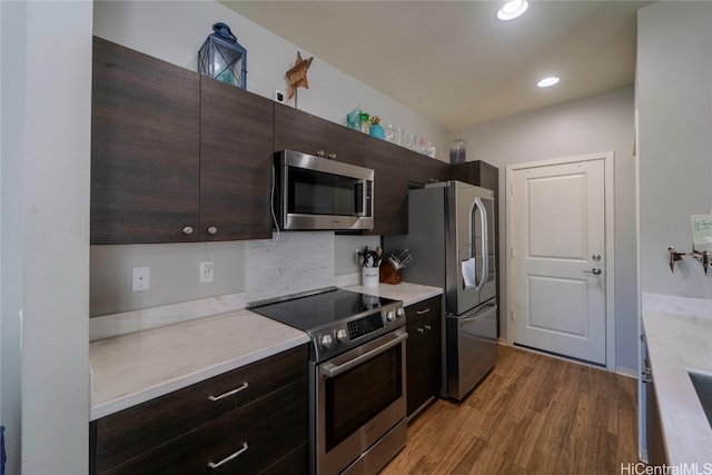 kitchen featuring hardwood / wood-style flooring, appliances with stainless steel finishes, dark brown cabinetry, and decorative backsplash