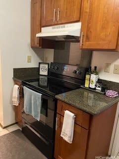 kitchen with light tile patterned flooring, dark stone countertops, and electric range