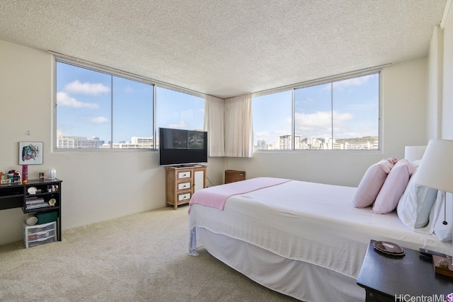 bedroom featuring carpet, a wall of windows, and a textured ceiling