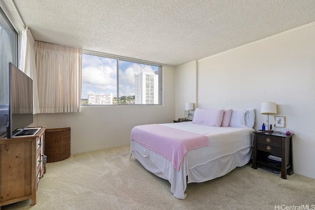 bedroom featuring light carpet and a textured ceiling