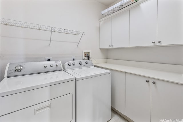 clothes washing area with cabinets, washer and clothes dryer, and light tile patterned flooring