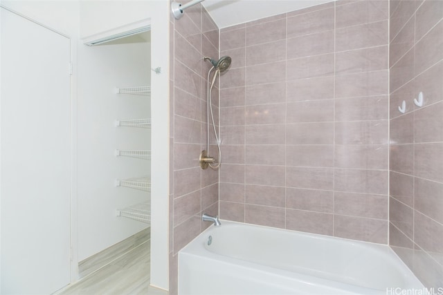 bathroom with tiled shower / bath combo and hardwood / wood-style flooring