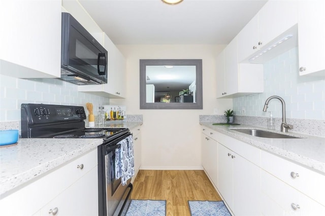 kitchen with black microwave, a sink, white cabinetry, electric stove, and light stone countertops