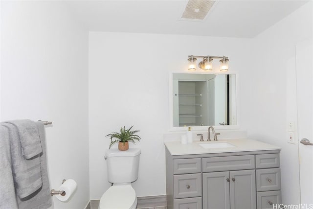 bathroom featuring visible vents, vanity, and toilet