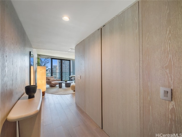 corridor featuring light wood-type flooring and floor to ceiling windows