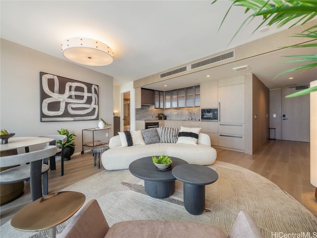 living room with light hardwood / wood-style flooring and sink