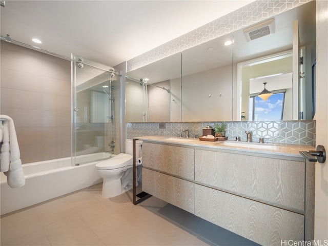 full bathroom with tasteful backsplash, toilet, vanity, tiled shower / bath combo, and tile patterned floors