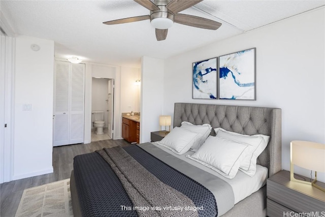 bedroom with a closet, ceiling fan, dark wood-type flooring, and ensuite bathroom