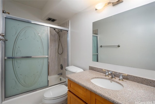 full bathroom featuring vanity, combined bath / shower with glass door, and toilet